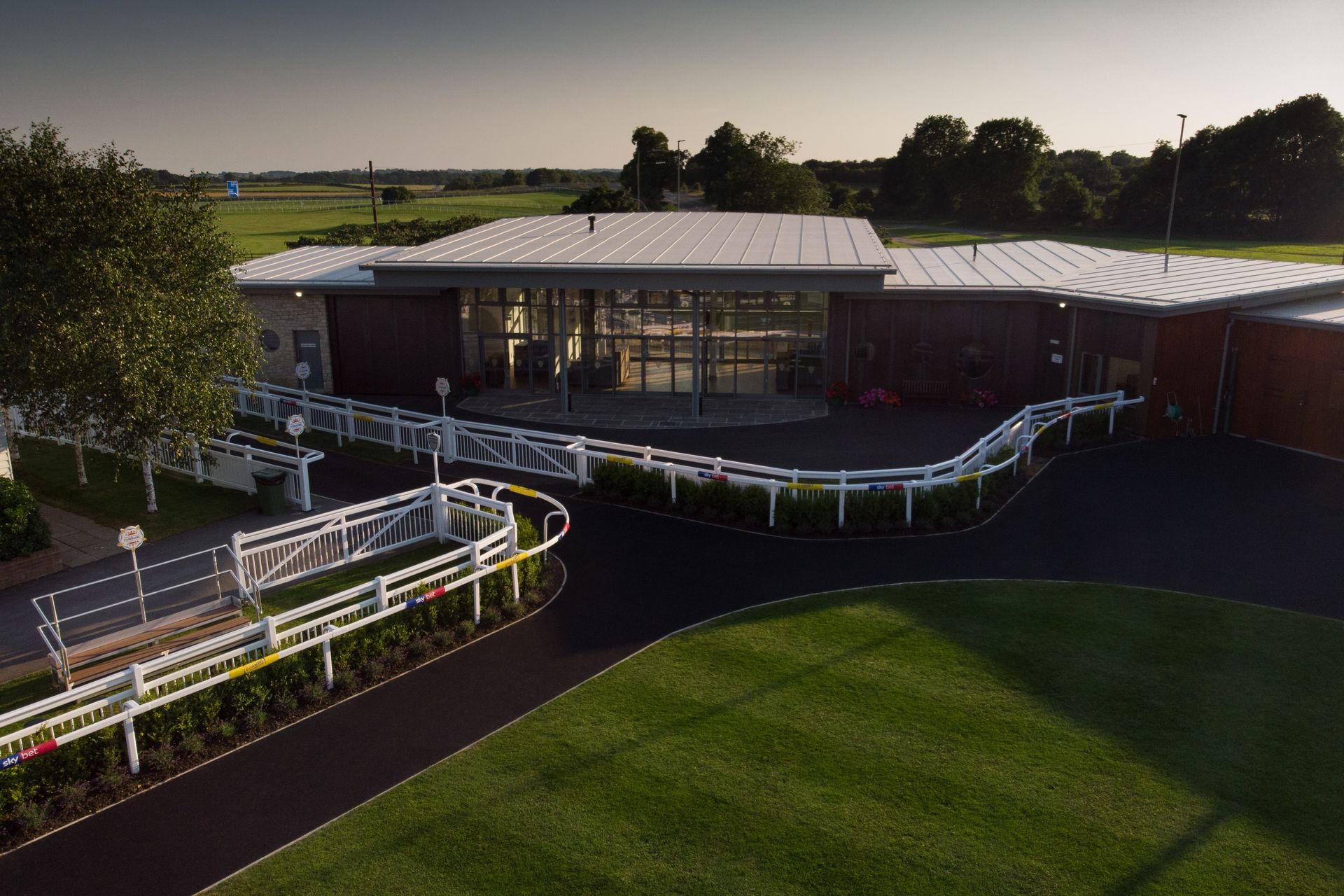 An aerial view of a race track with a large building in the background.