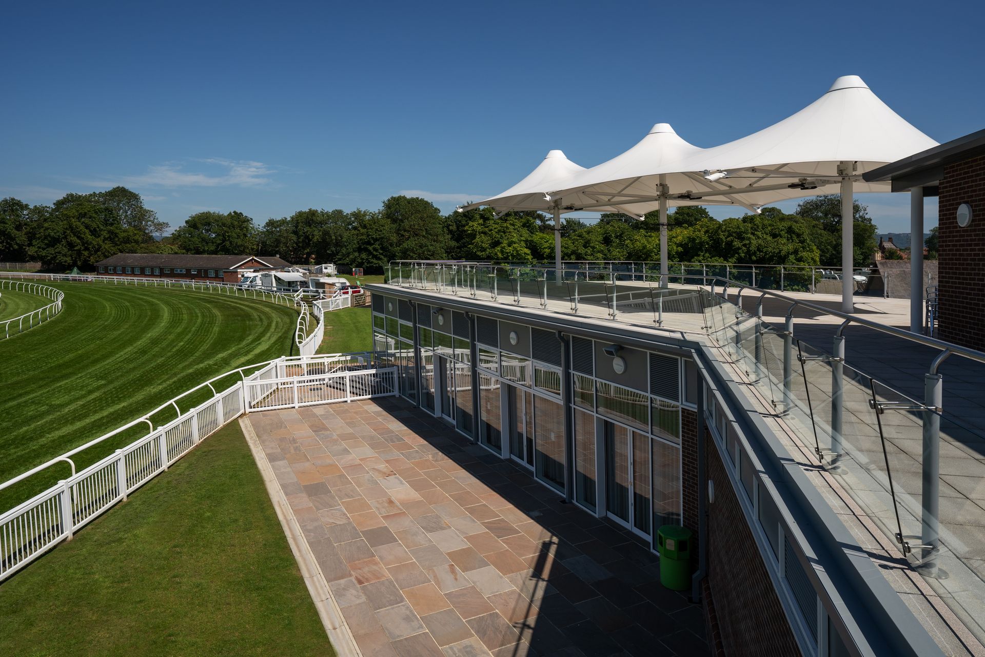 A view of a race track from a balcony with umbrellas