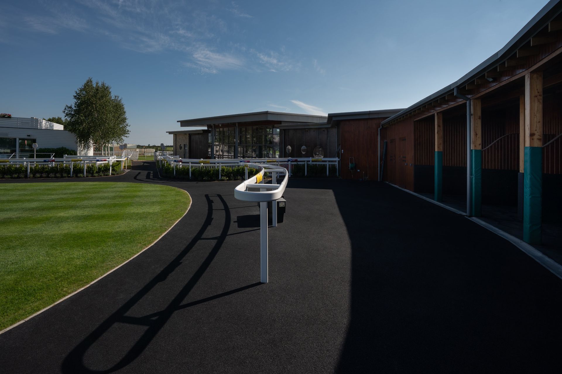 A shadow of a horse is cast on the ground in front of a building.