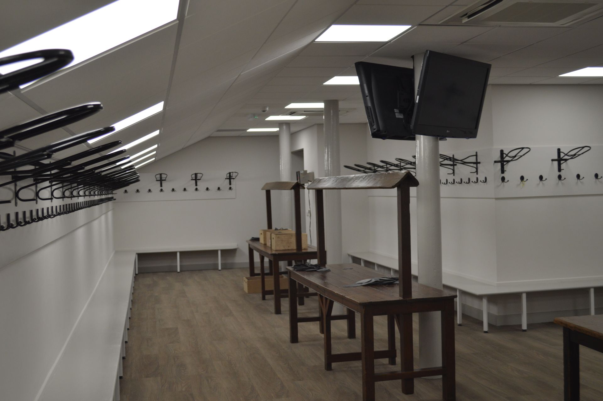 A locker room with a lot of hooks and tables
