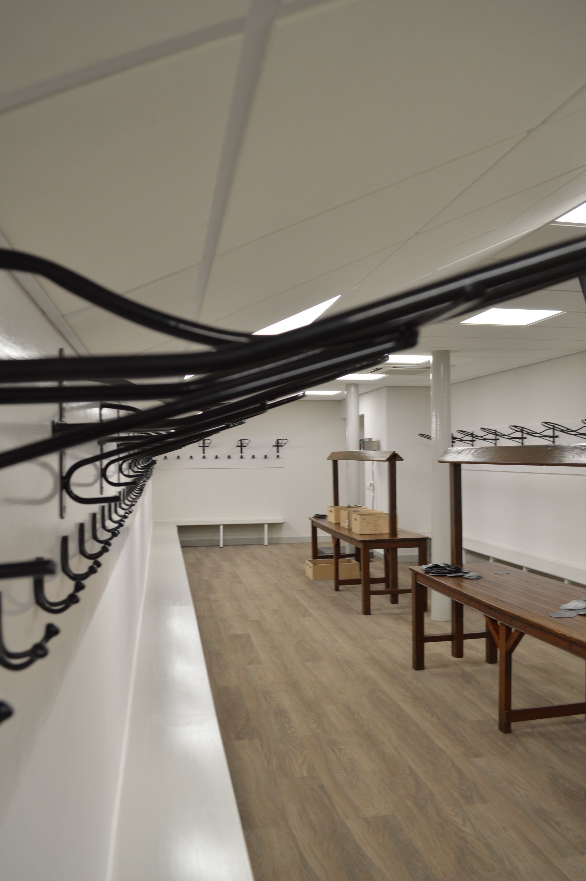 A locker room with a long row of hooks and benches.
