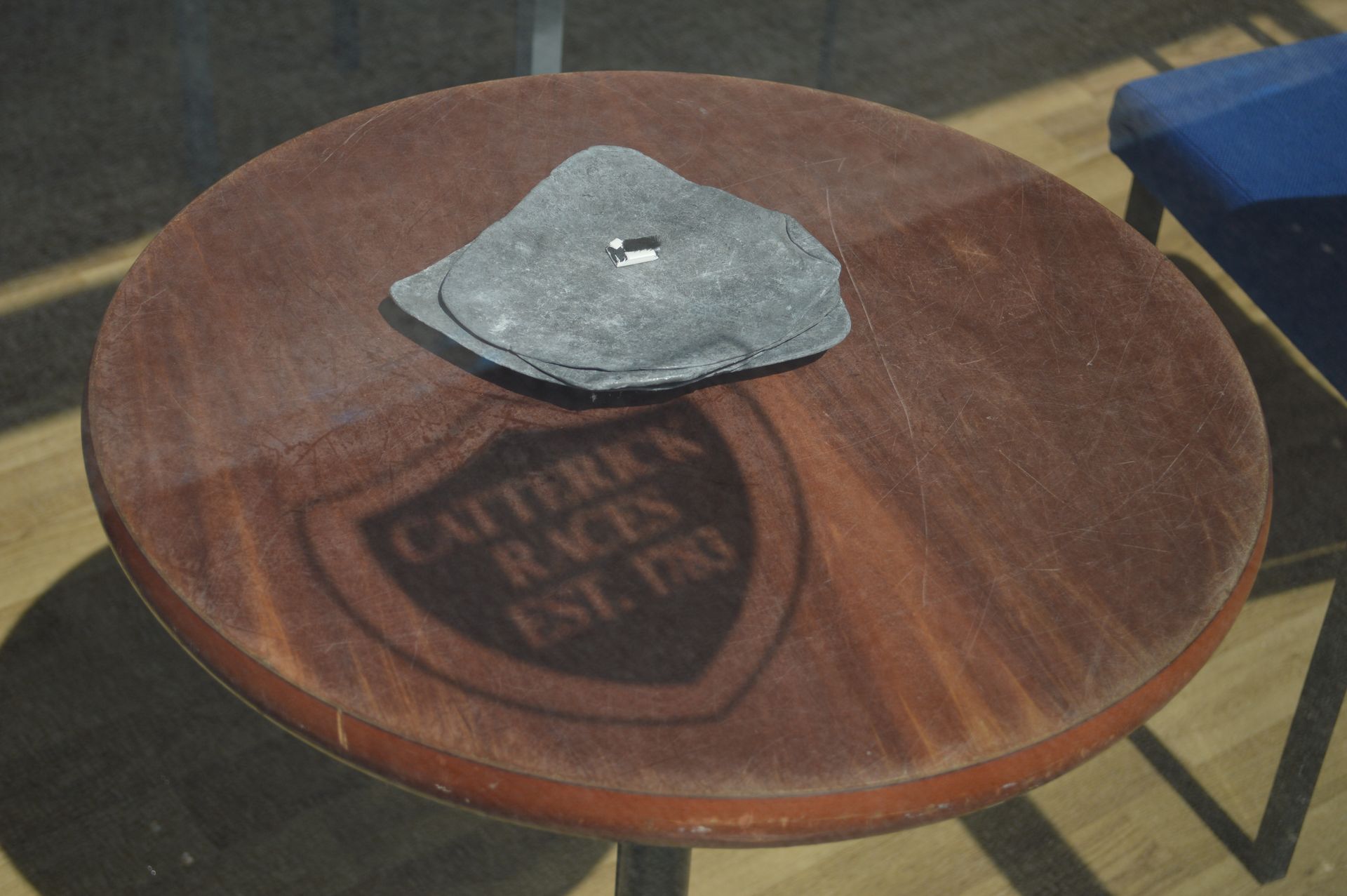 A round wooden table with a shield on it that says caterra