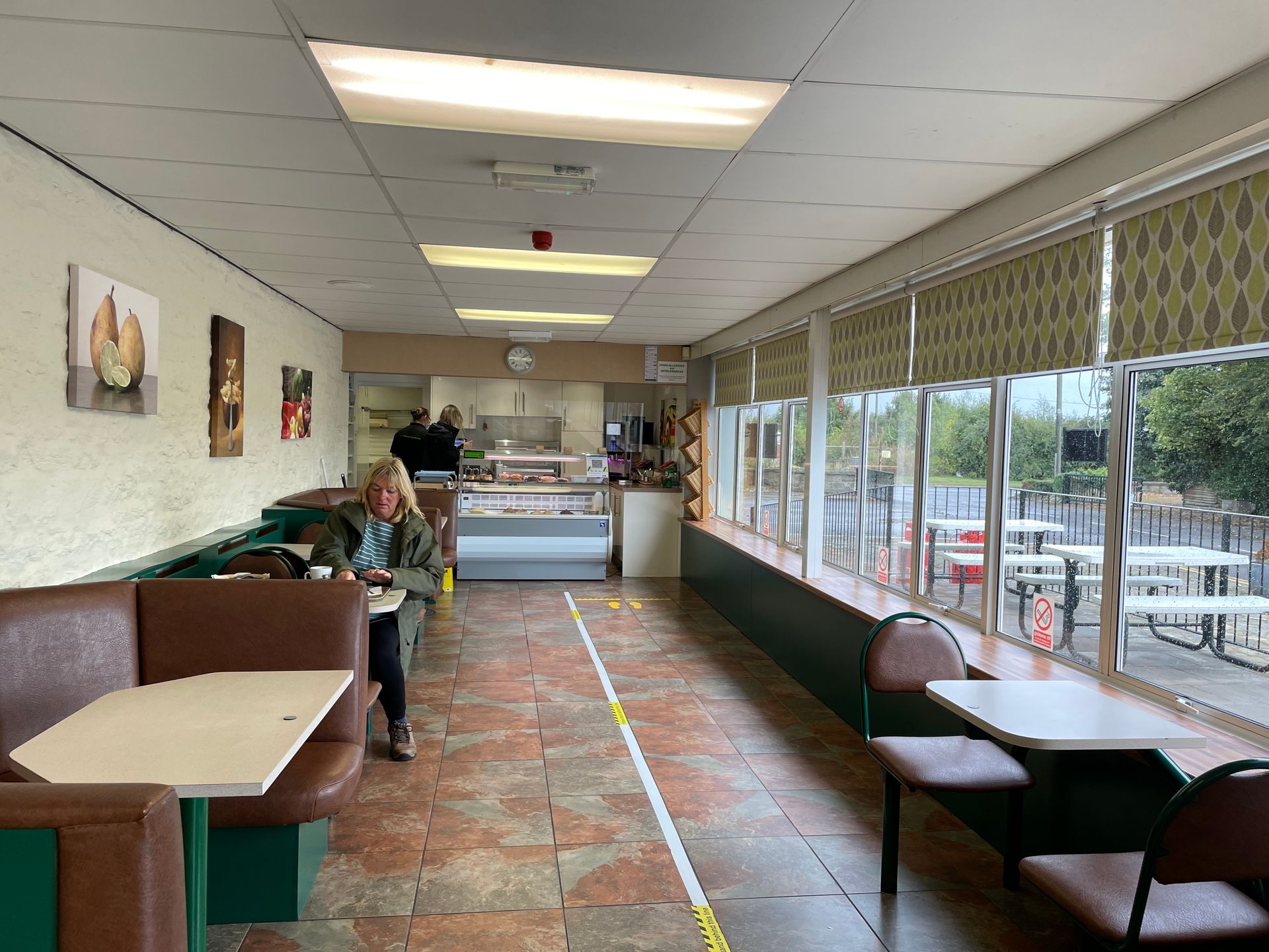 A woman is sitting in a booth in a restaurant.