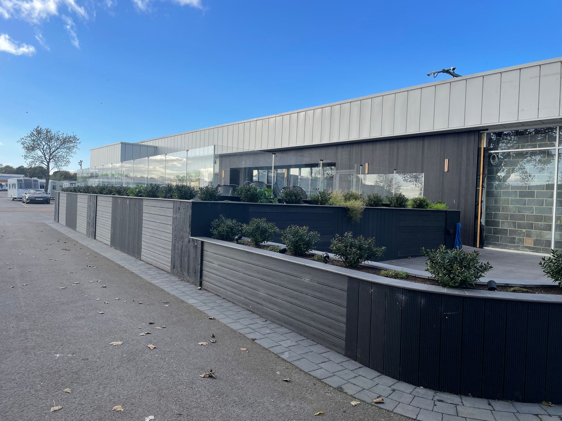 A large building with a lot of windows and plants in front of it.