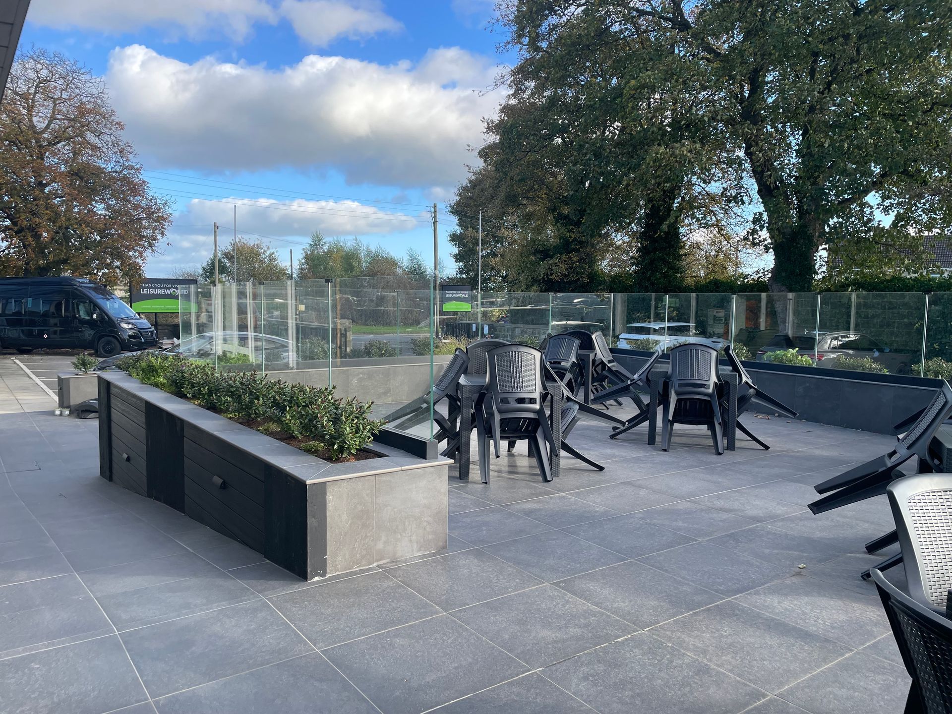 A patio with a table and chairs and a planter.