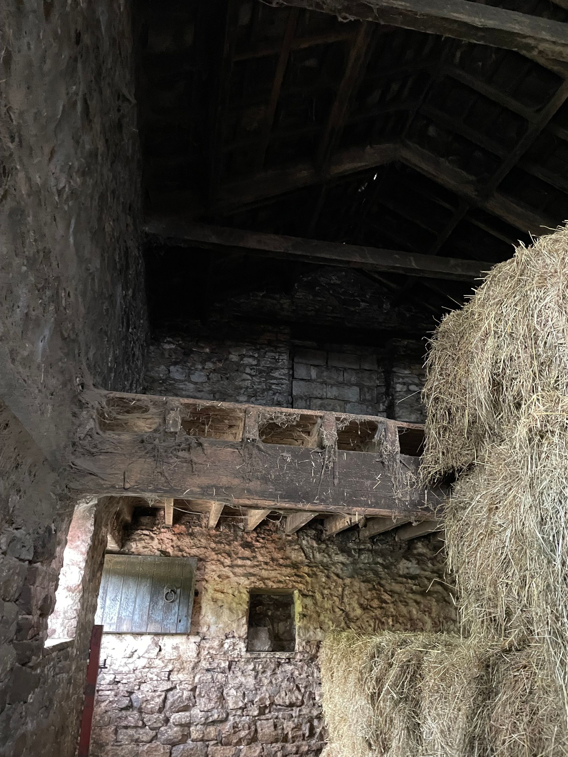 A large pile of hay is stacked on top of each other in a barn.