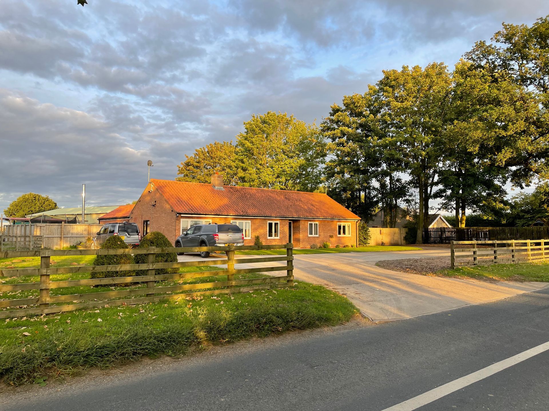 A house with a red roof is sitting next to a road.
