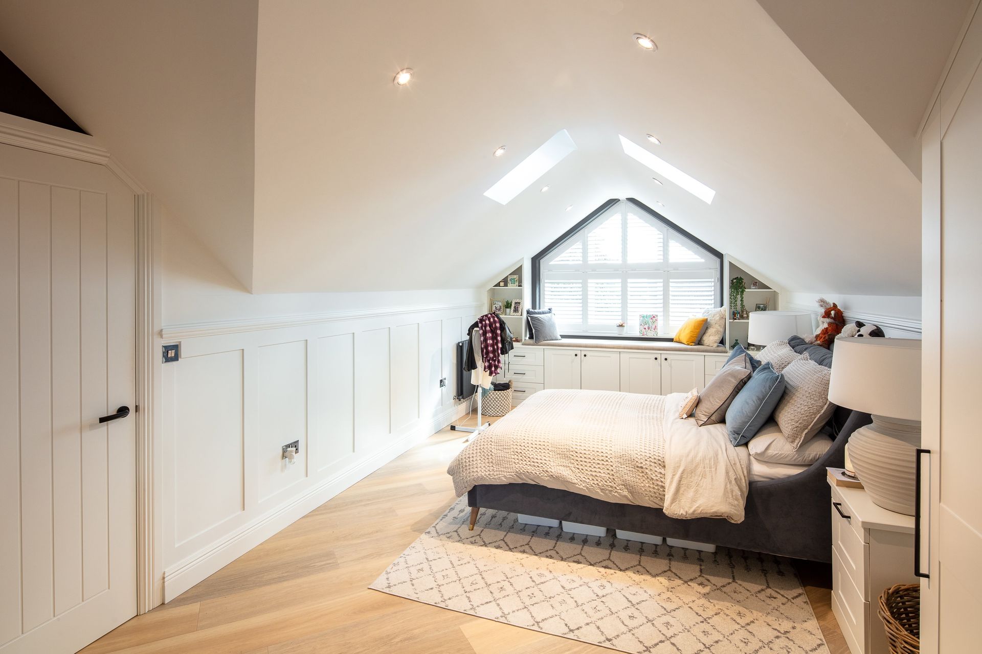 A bedroom with a bed and a window in the attic.