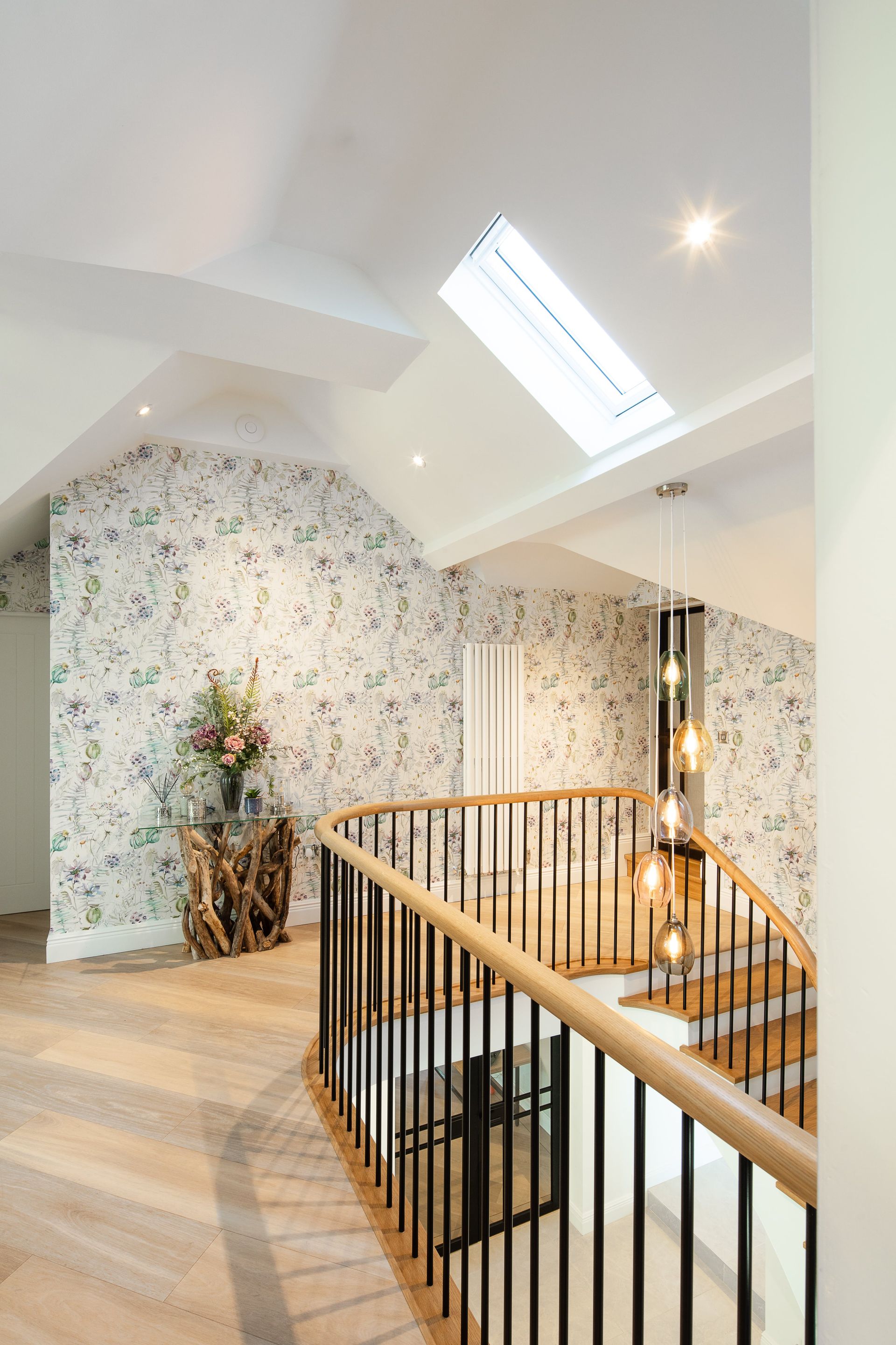 A staircase with a wooden railing and a skylight in the ceiling.