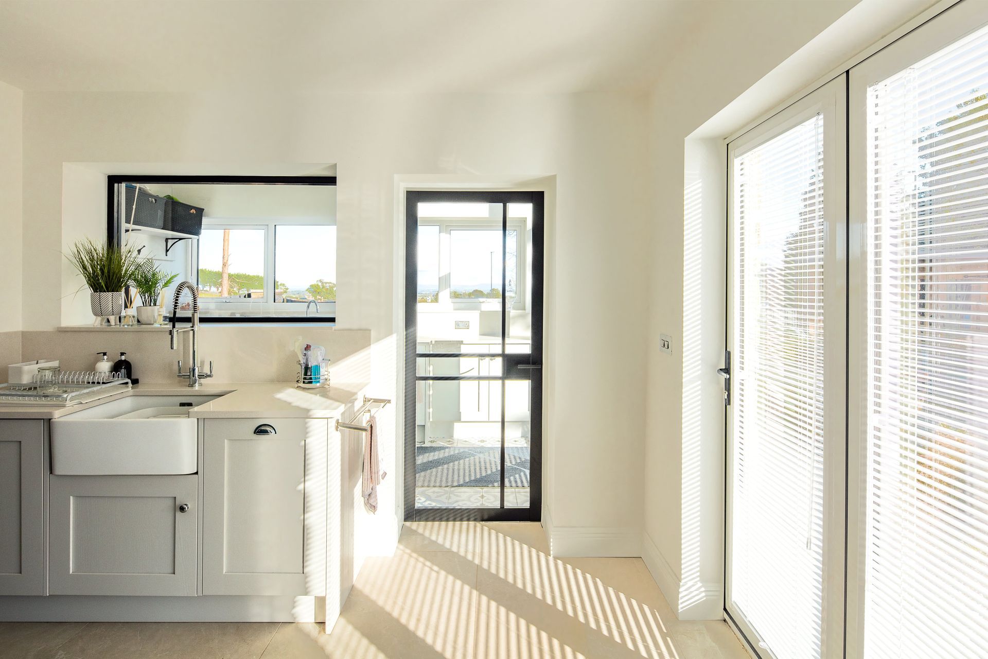 A kitchen with a sink , cabinets , and sliding glass doors.