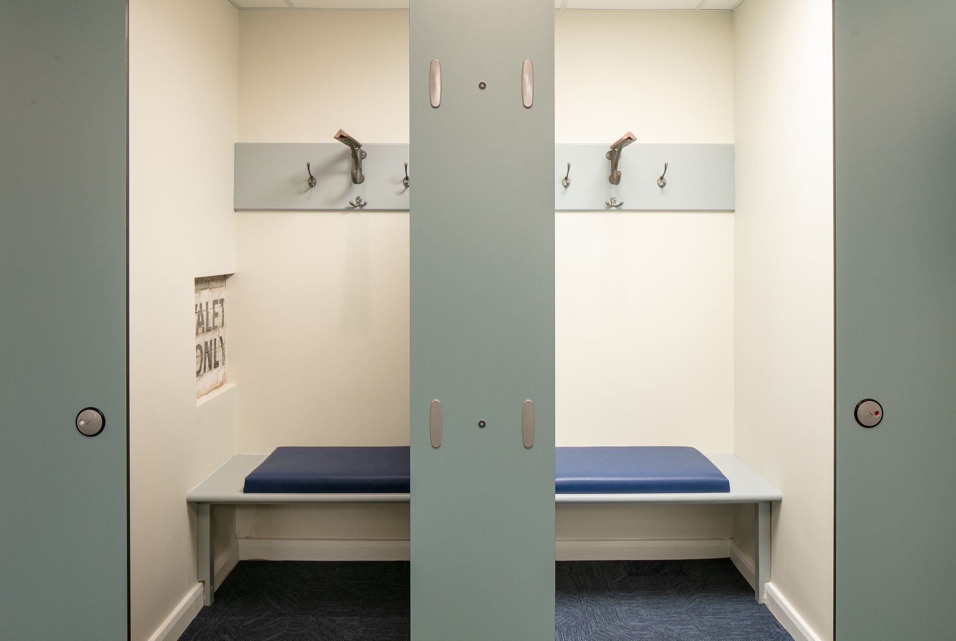A locker room with a bench and hooks on the wall