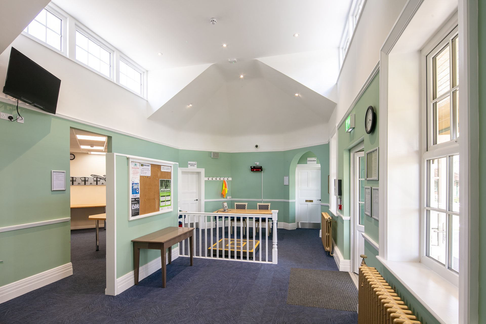 A large room with green walls and a clock on the wall.