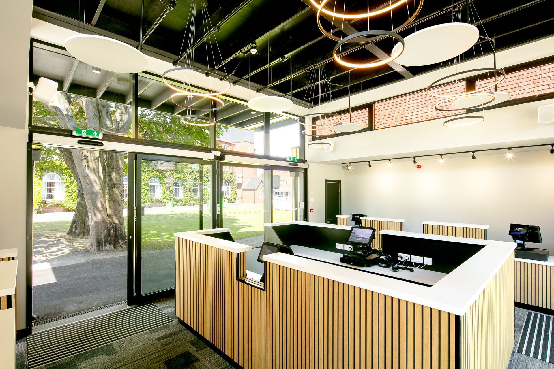 A reception area in a building with a wooden counter and a computer on it.
