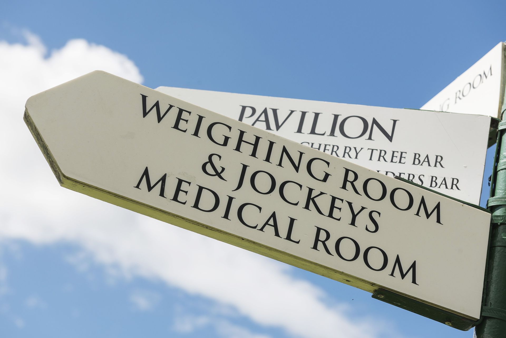 A sign pointing to pavilion weighing room and jockeys medical room