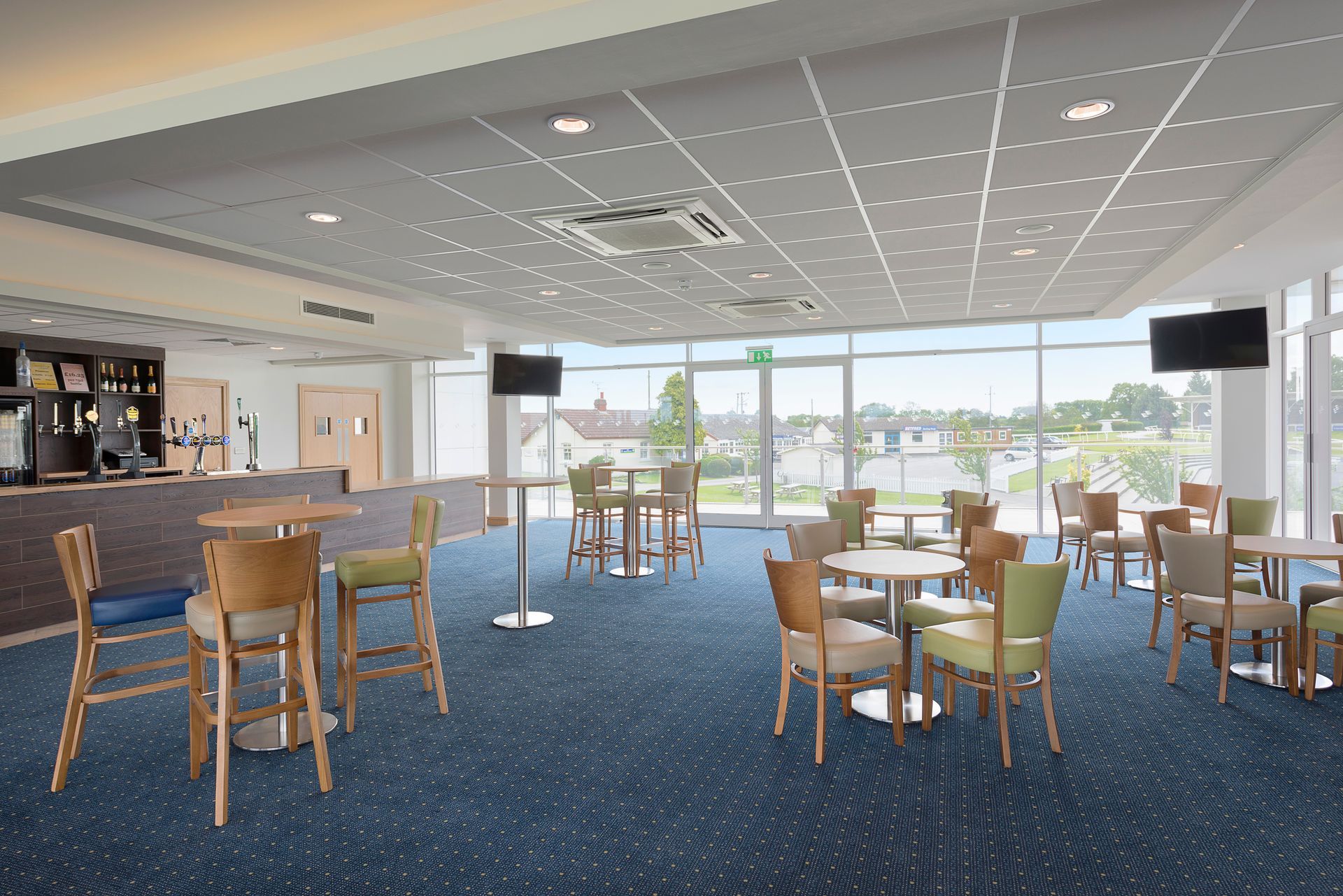 A large room with tables and chairs and a bar.