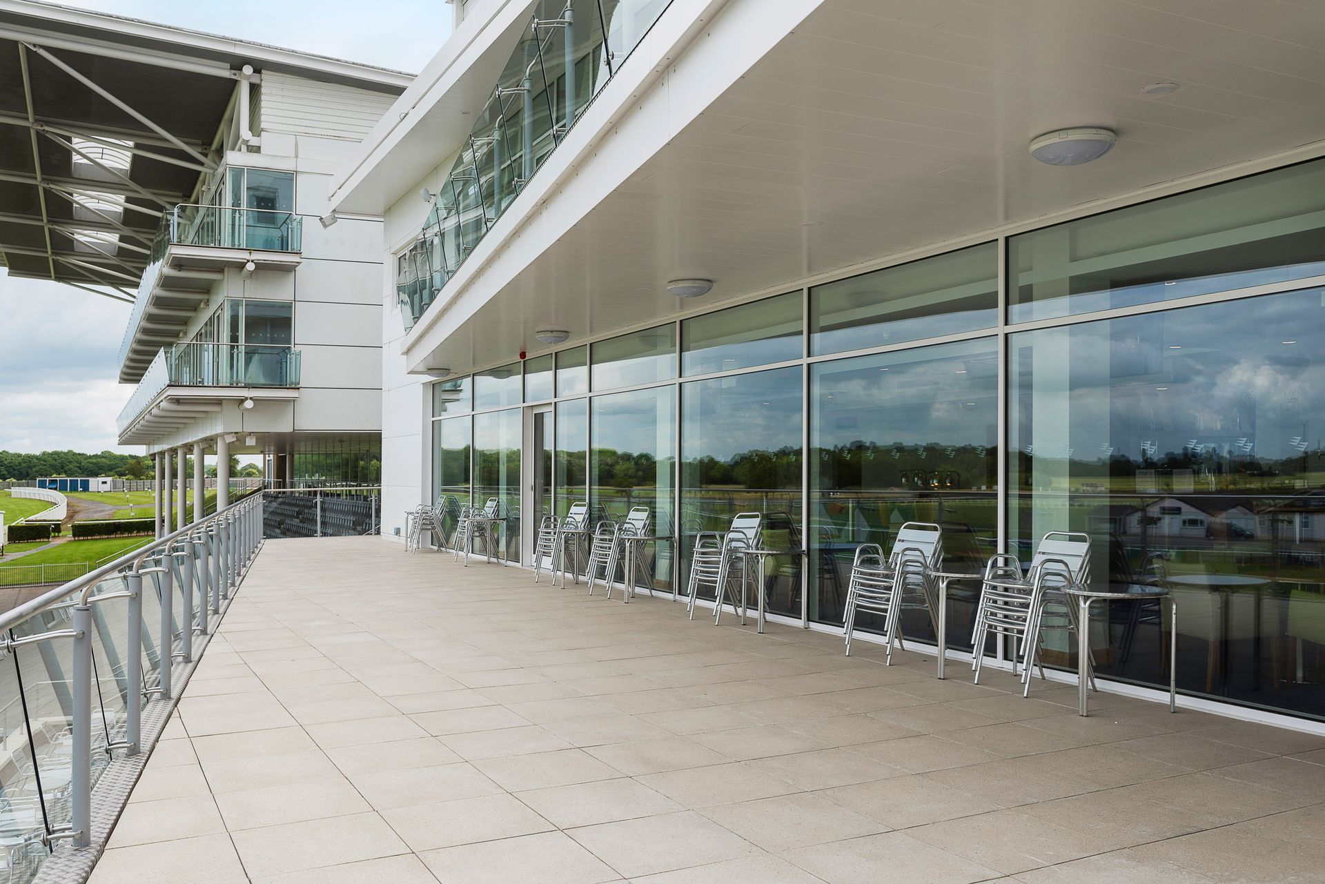 A large building with a balcony and chairs in front of it