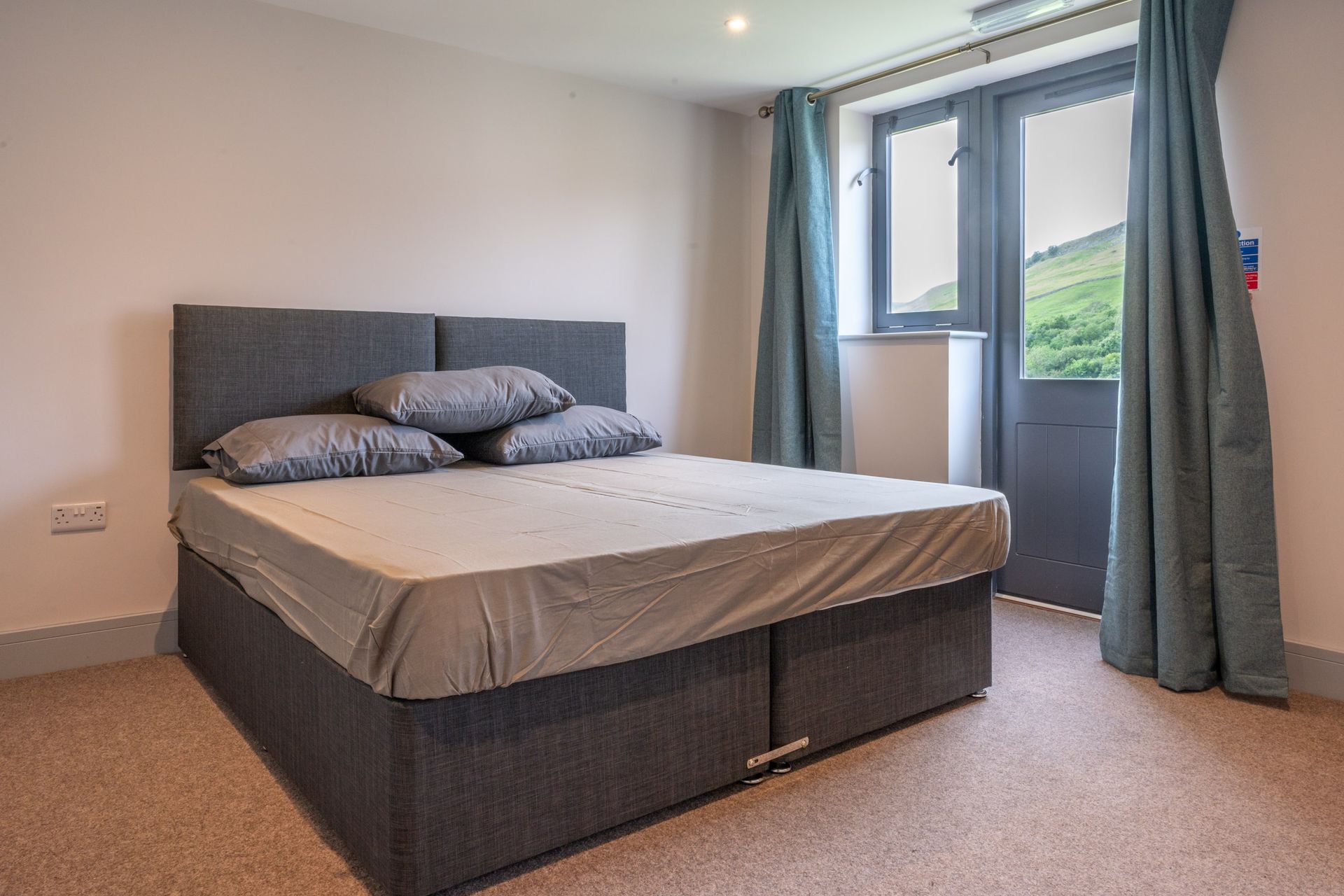 A bedroom with a large bed and a balcony.