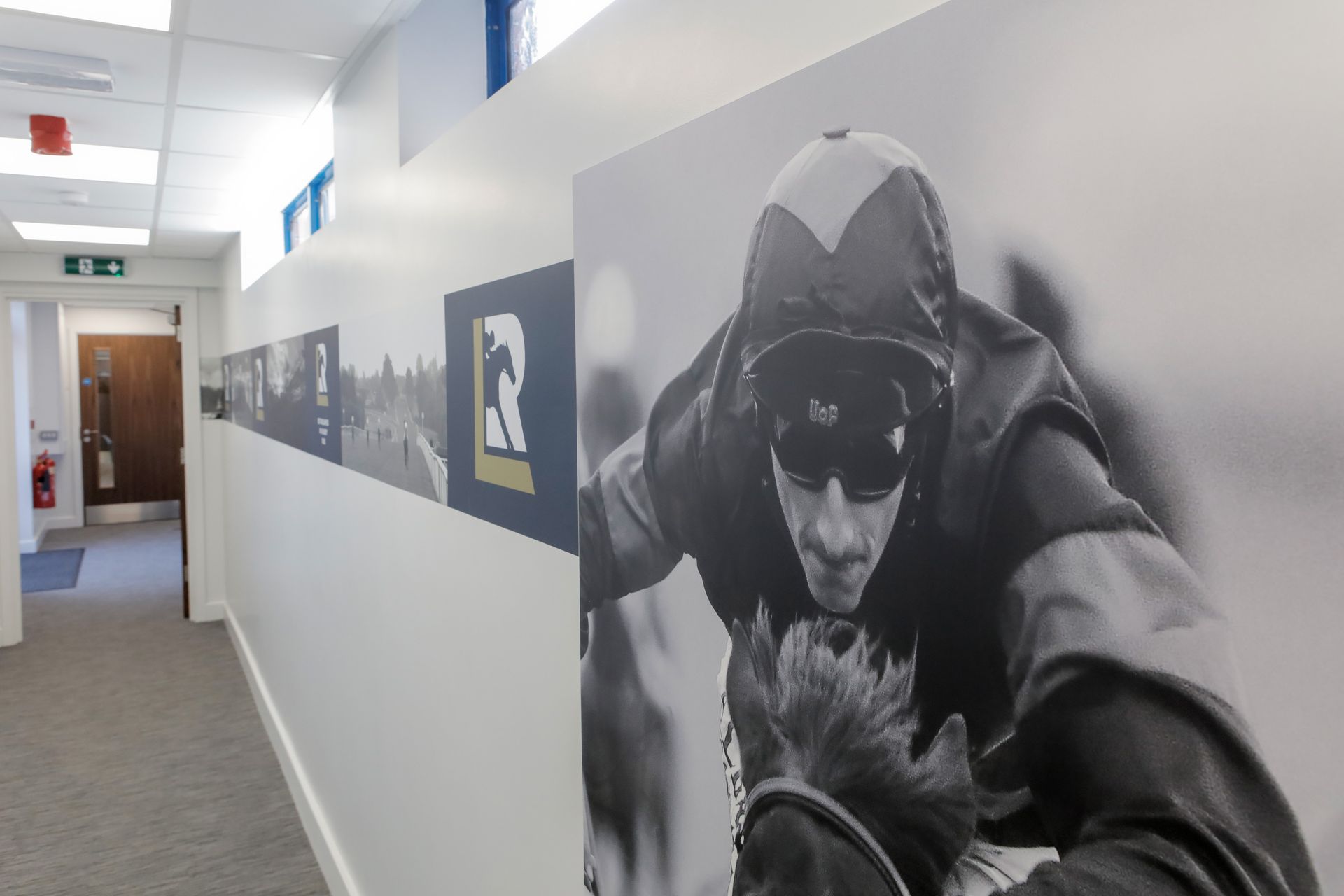 A black and white photo of a man riding a horse