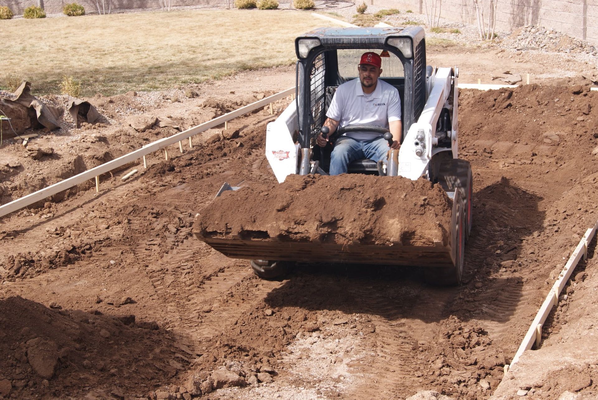 A man is driving a bulldozer on a dirt road