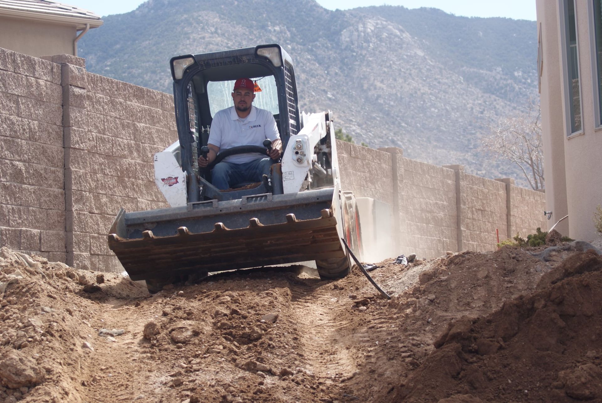 A man is driving a bulldozer on a dirt road