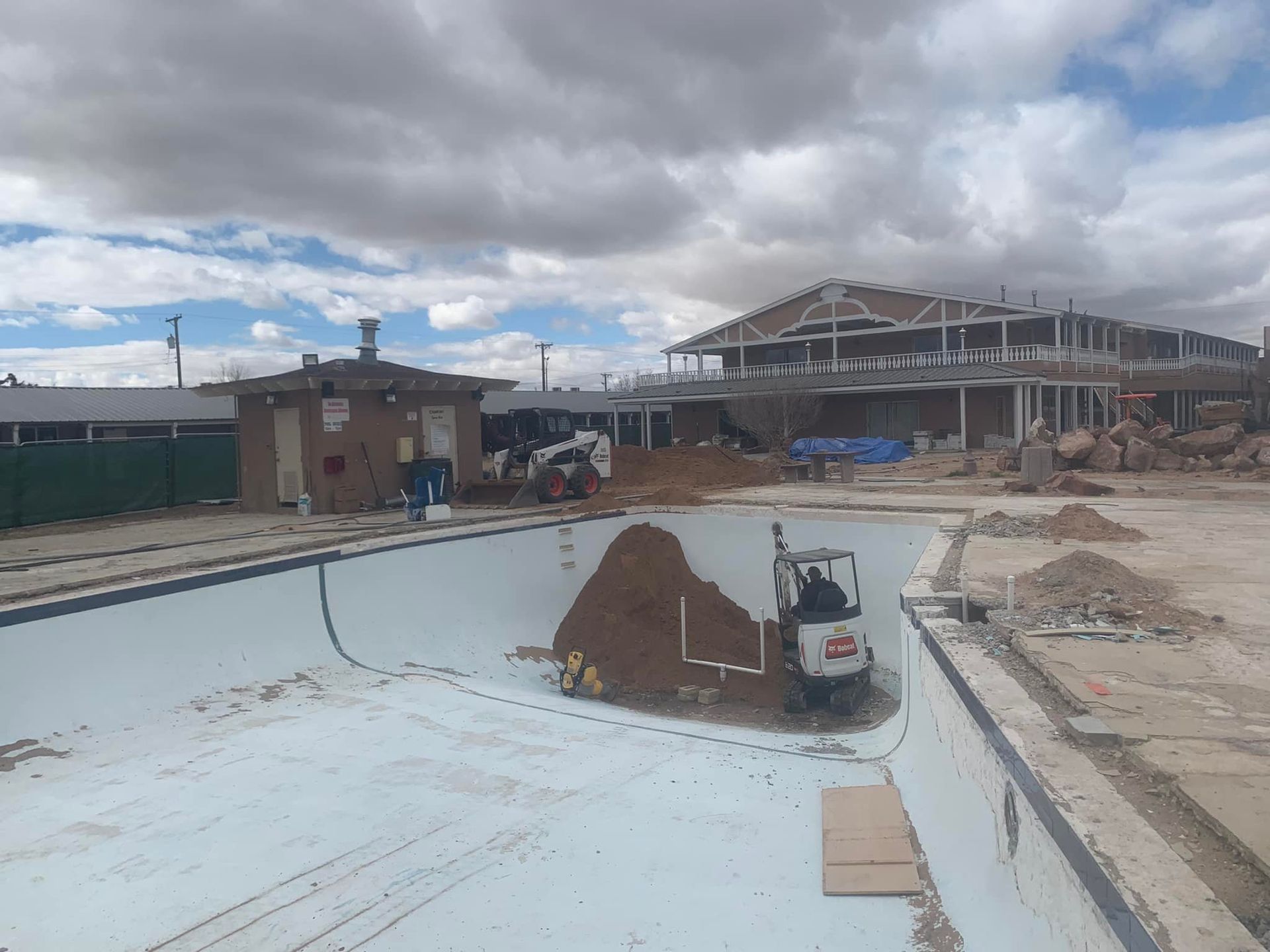 A large building is being built next to a swimming pool.