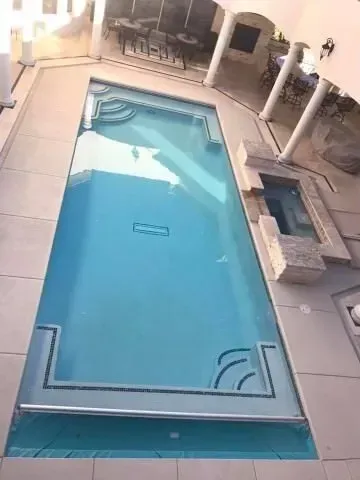 An aerial view of a large swimming pool in a house.
