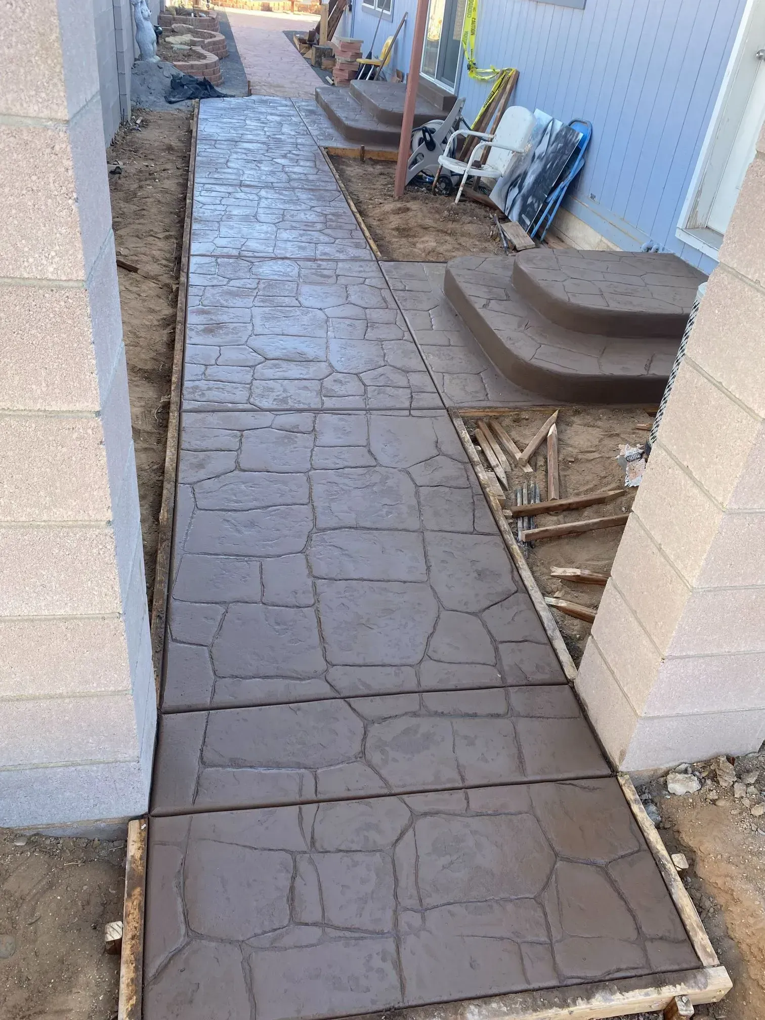 A concrete walkway is being built in front of a house.