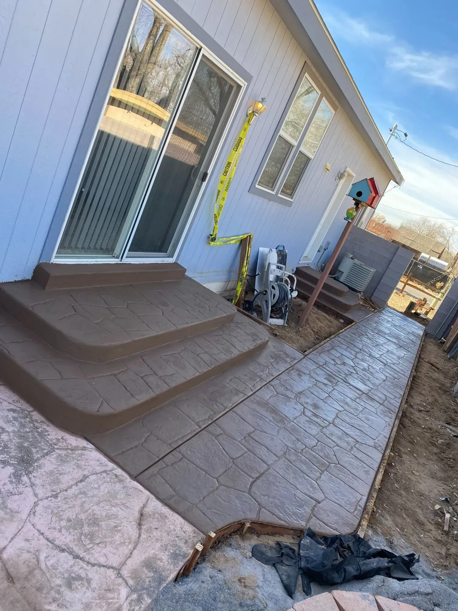 A house with a concrete walkway and stairs in front of it.