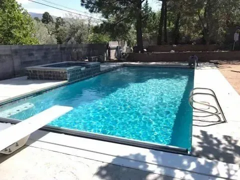 A large swimming pool with a diving board in the middle of it.