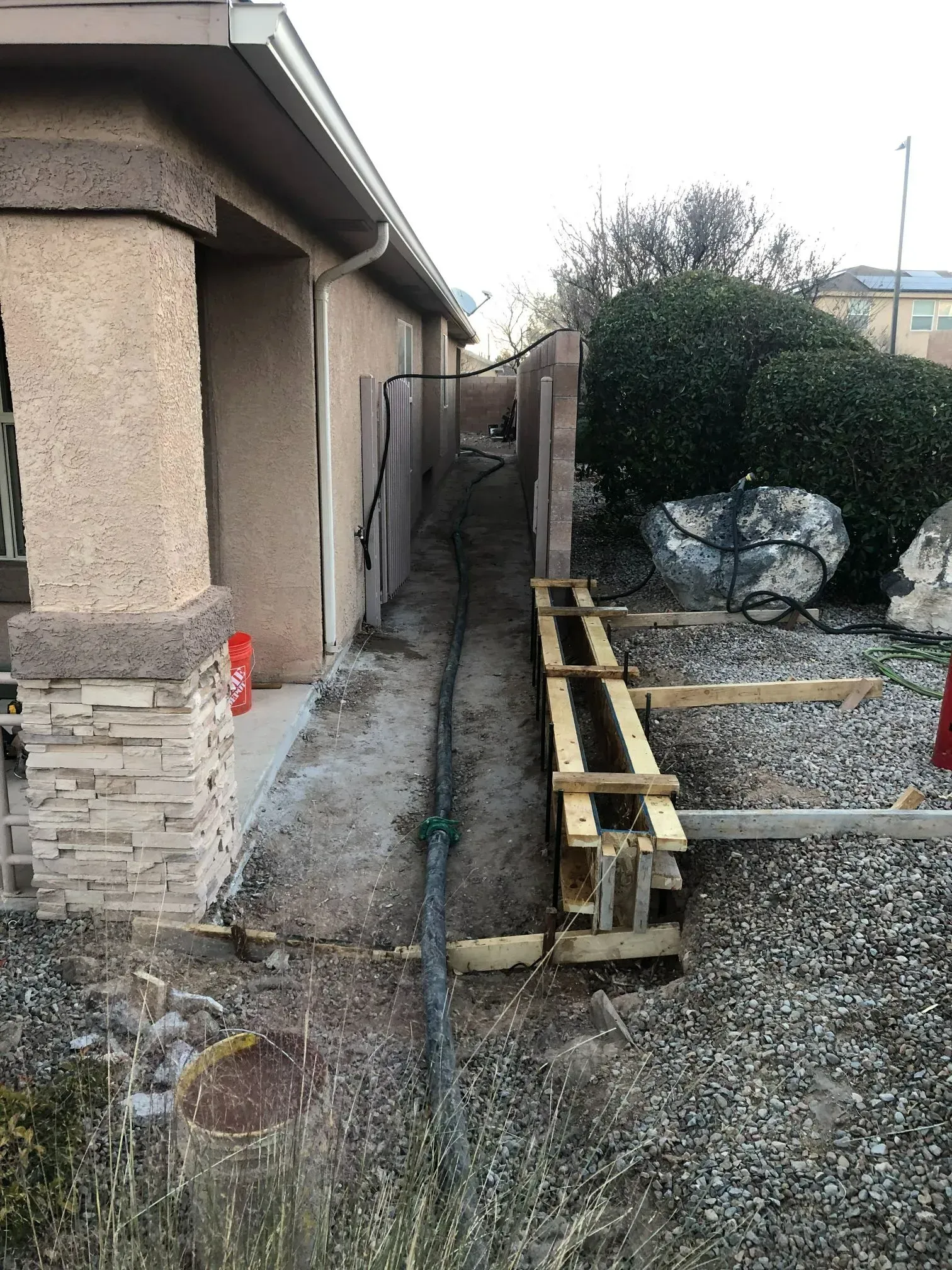 A concrete walkway is being built in front of a house.