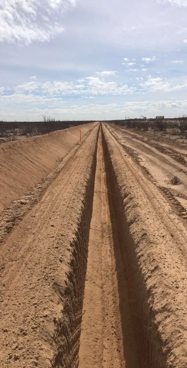 A dirt road with tire tracks in the middle of it.
