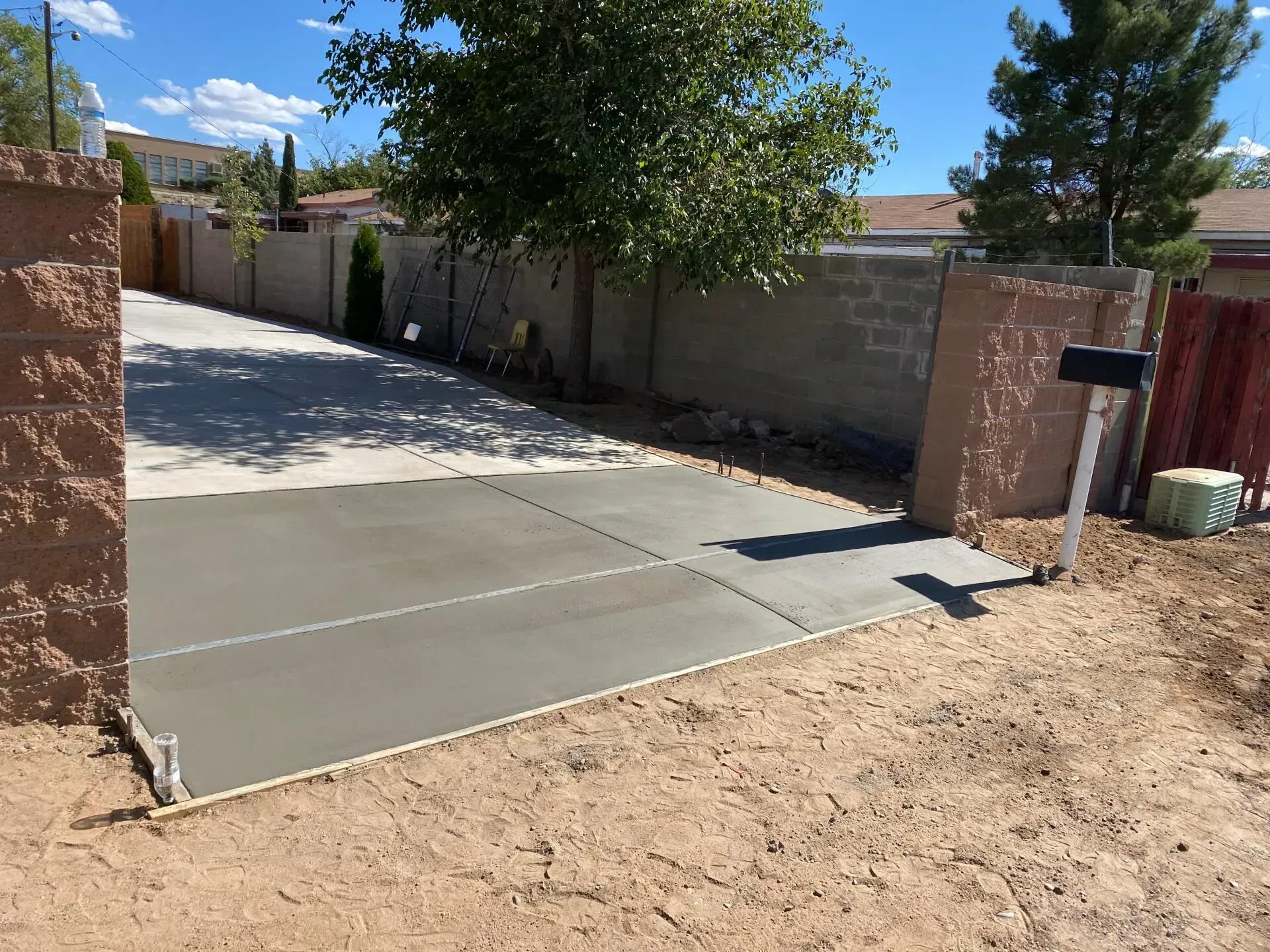 A concrete driveway with a mailbox on the side of it