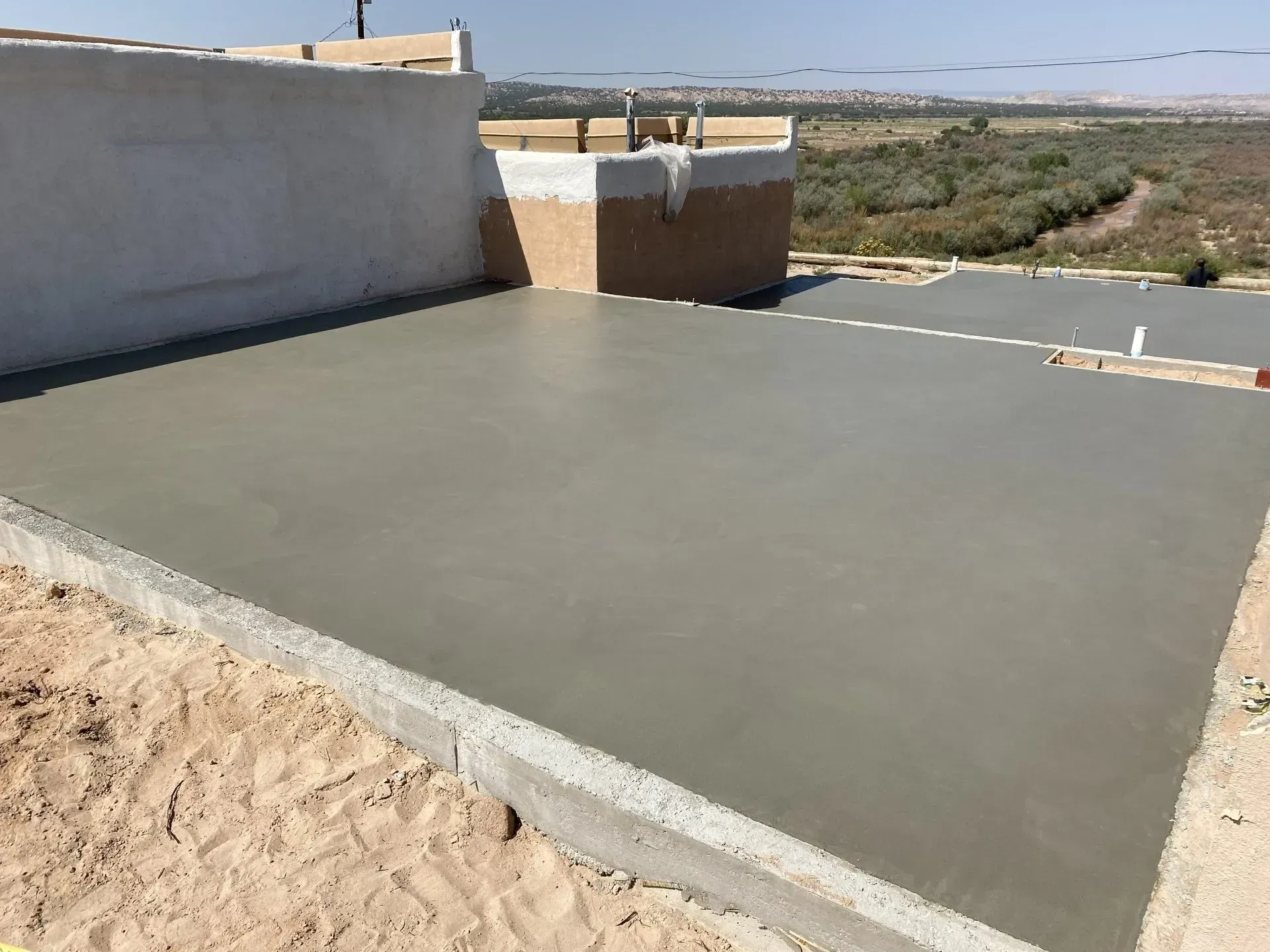 A concrete floor is being built next to a wall.