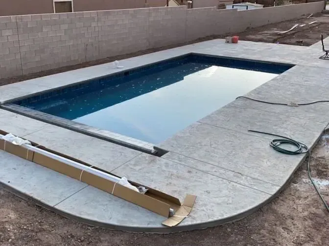 A large swimming pool is being built in a backyard