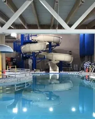 There is a water slide in the middle of the pool.