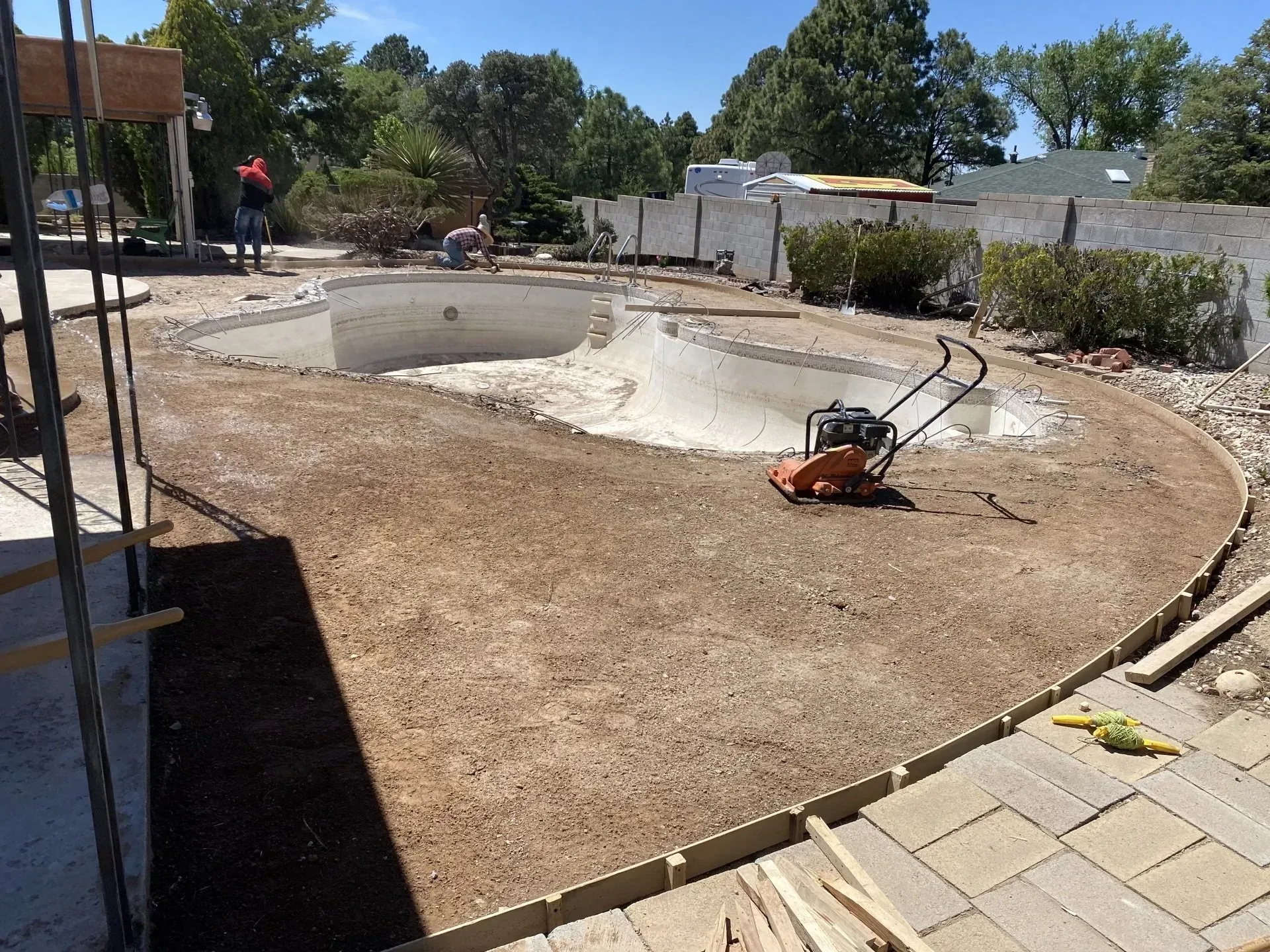 A pool is being built in the backyard of a house.