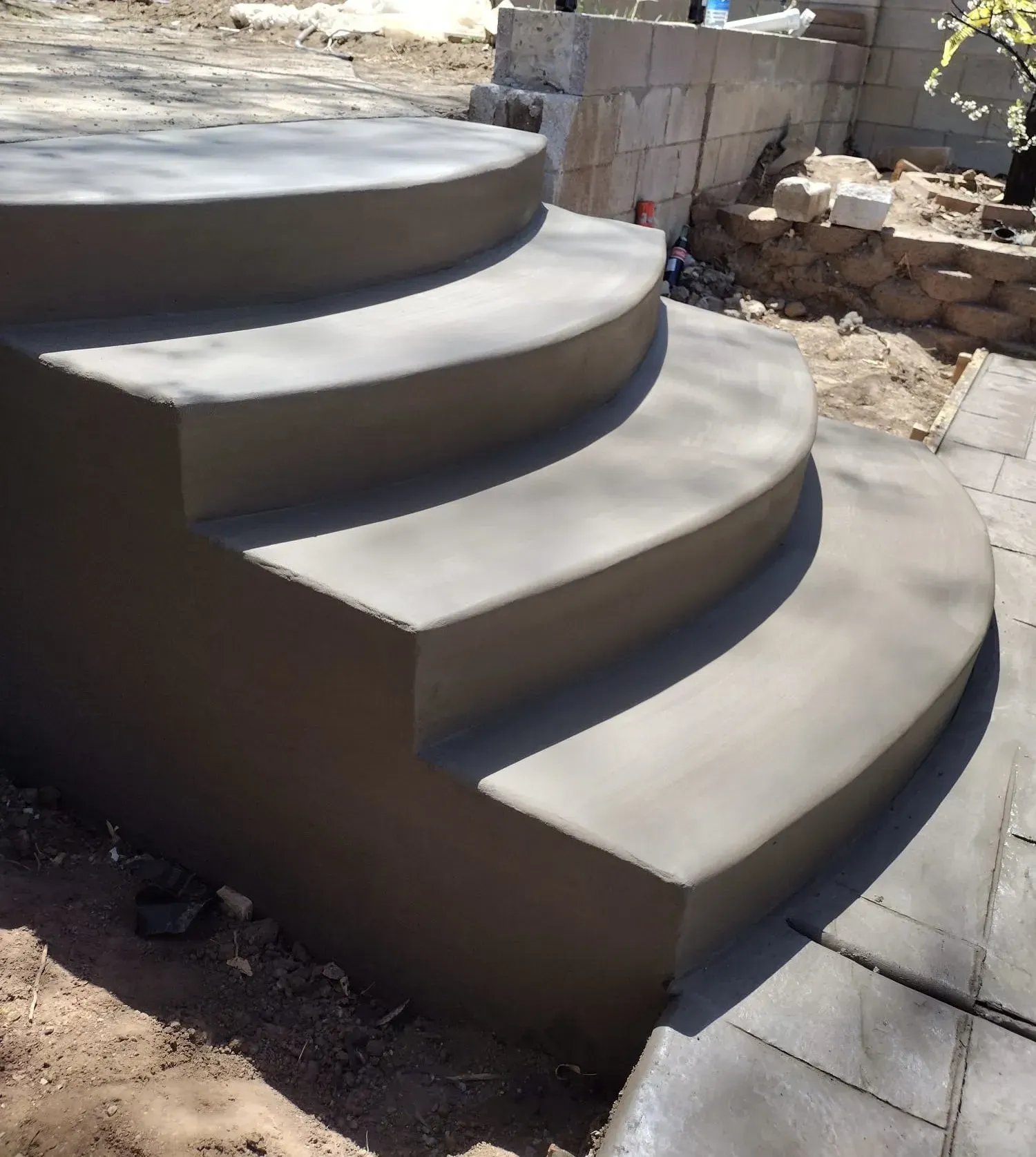 A set of curved concrete steps are being built