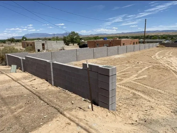 A concrete fence is being built in the desert