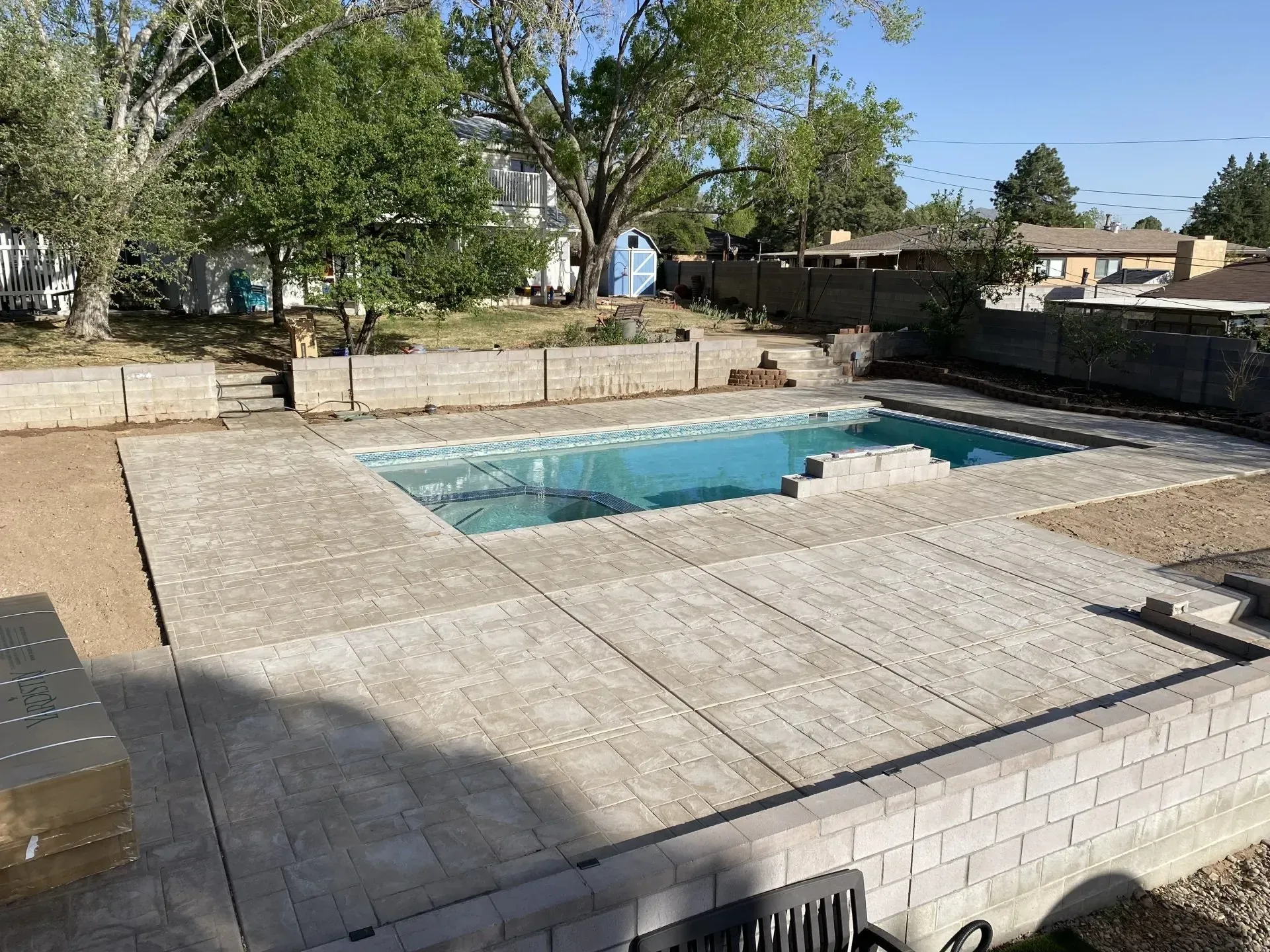 There is a large swimming pool in the backyard of a house.
