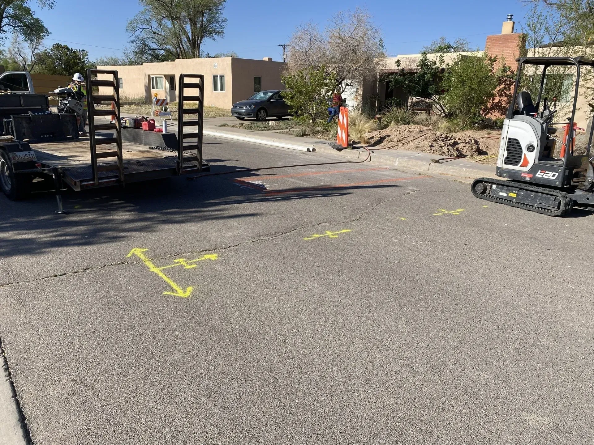 A bulldozer is parked on the side of the road next to a trailer.