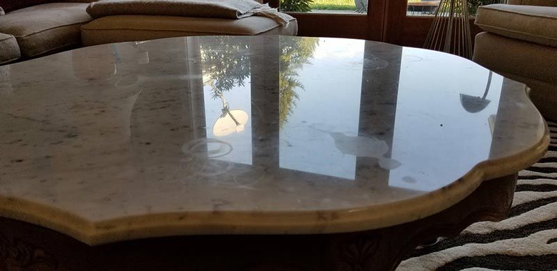 A round marble coffee table in a living room with a zebra print rug.