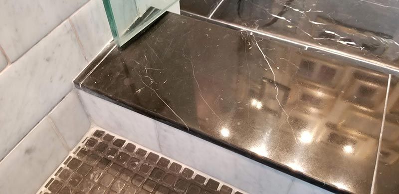 A bathroom with two sinks and a walk in shower.