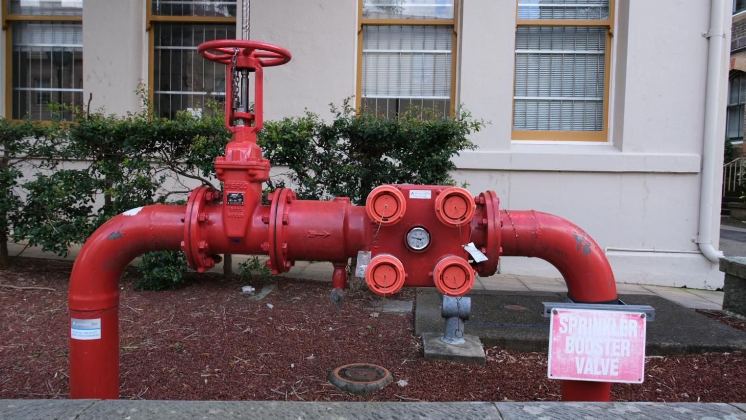 A red pipe with a sign on it that says storm drain.