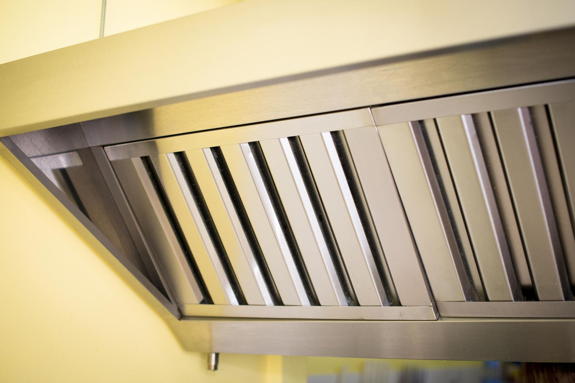 A close up of a stainless steel exhaust hood in a kitchen.
