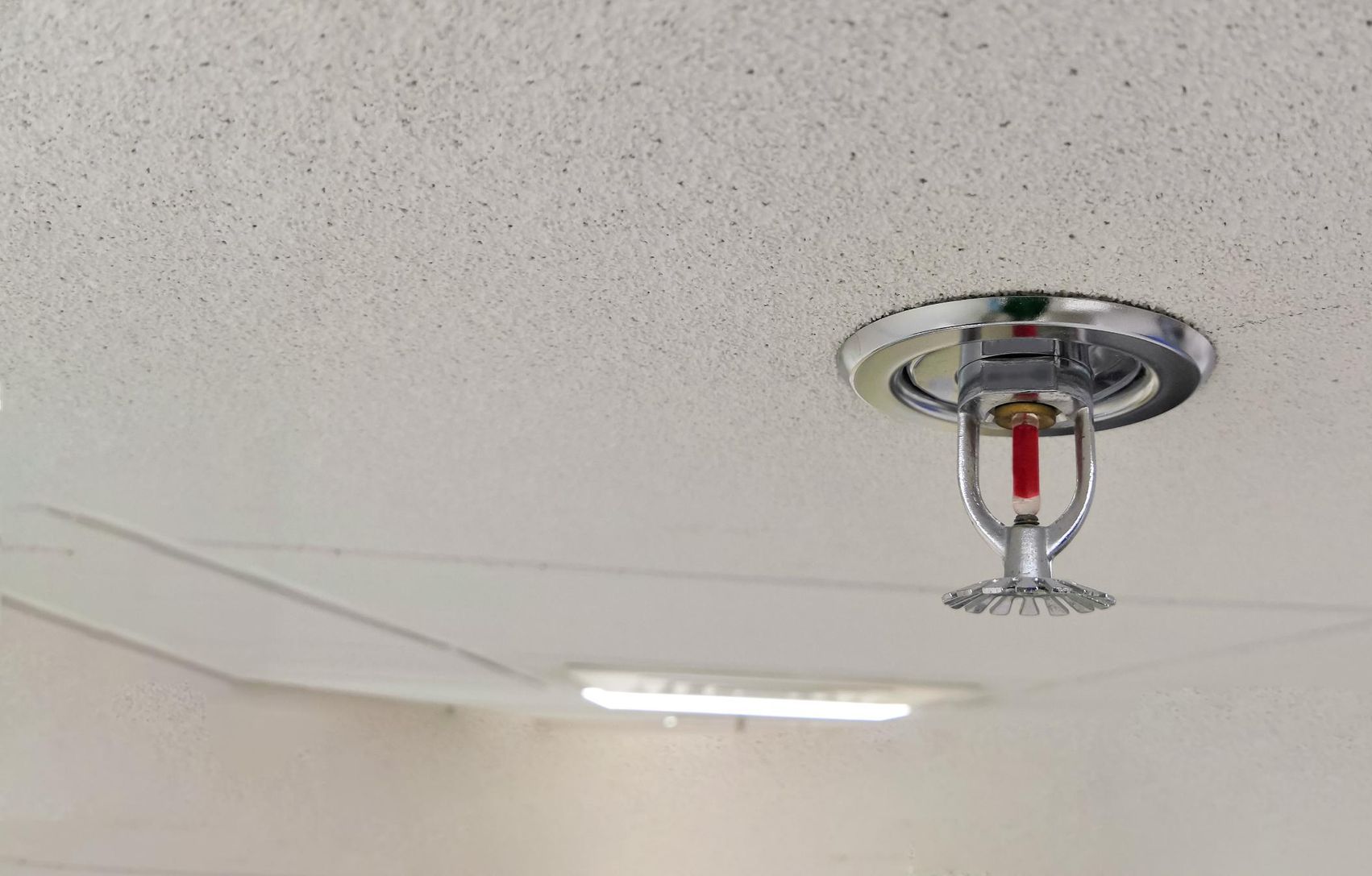 A fire sprinkler is hanging from the ceiling of a room.