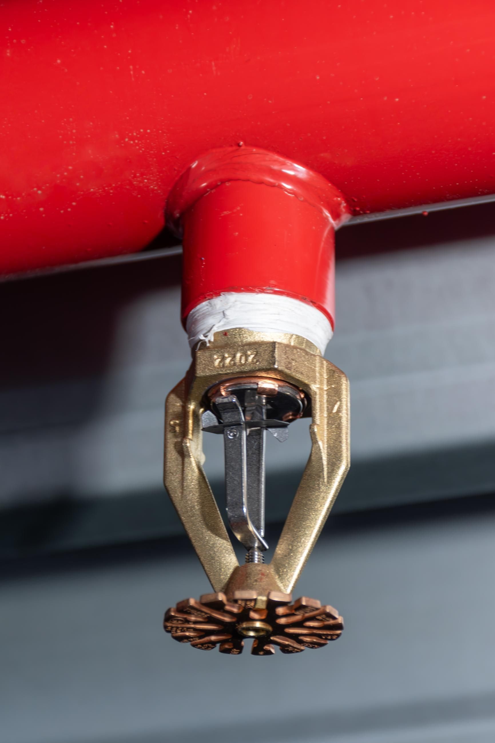A fire sprinkler is hanging from the ceiling of a building.