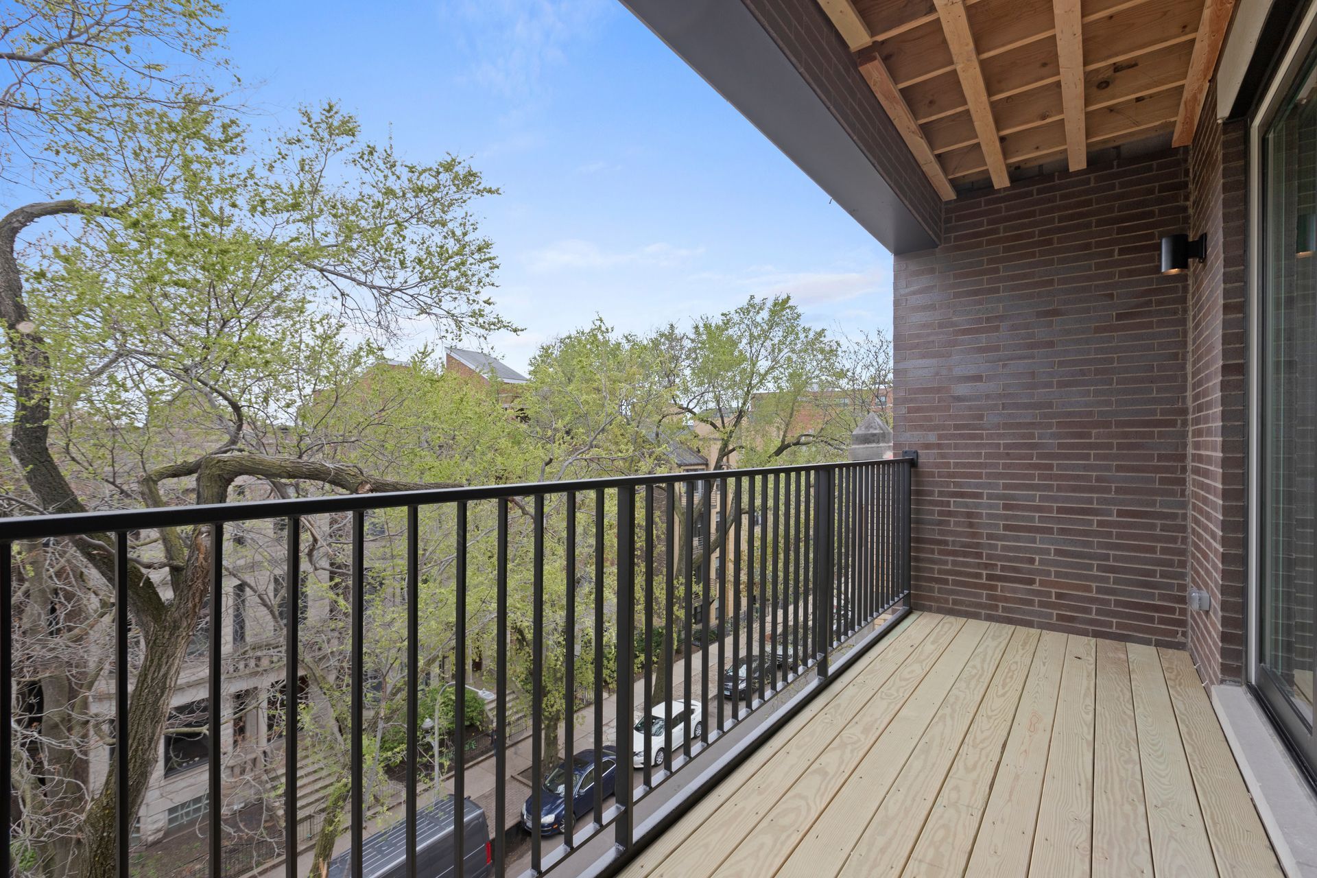 A balcony with a railing and a view of trees