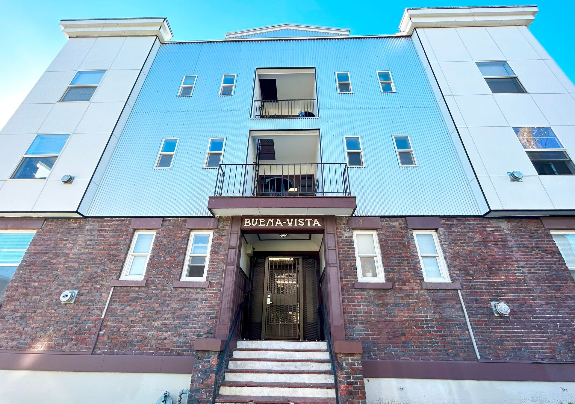 A large apartment building with stairs leading up to the entrance