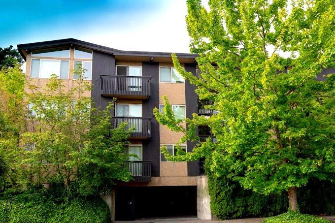 A large apartment building with trees in front of it