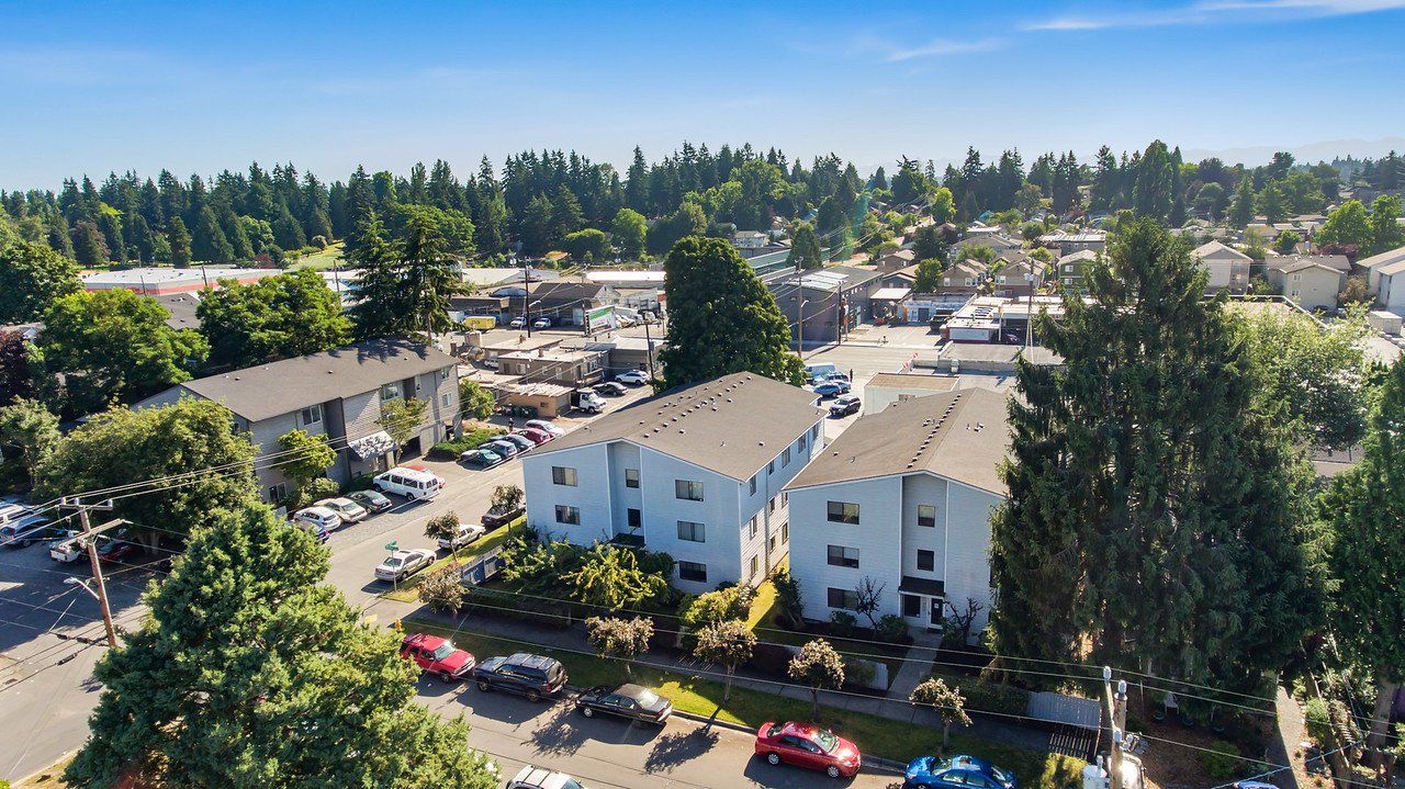An aerial view of a residential area with a lot of cars parked in front of a building.